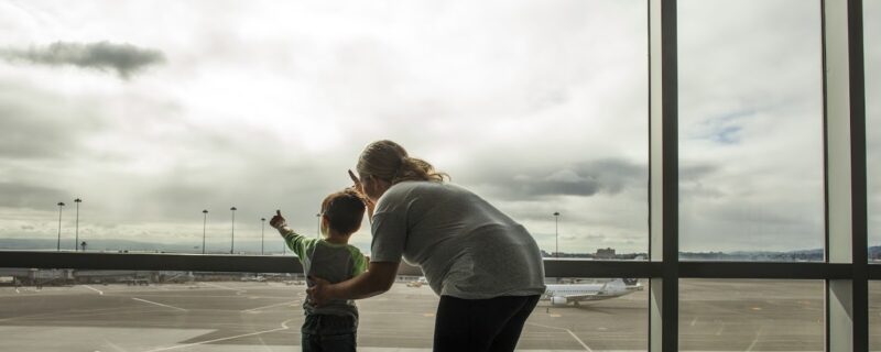 Mother and son looking out airport window